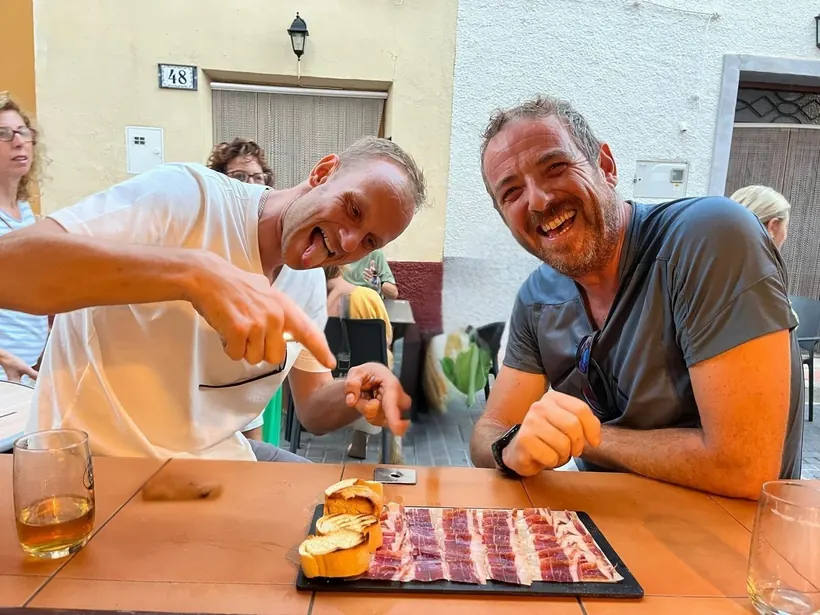 Amigos compartiendo jamón en la terraza